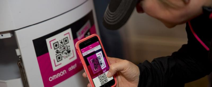 Event attendee scanning a QR code on a robot with the event app
